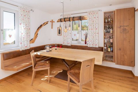 Esszimmer in Eiche Massivholz mit beleuchteter Whiskyvitrine und Schranktür mit Baumkante